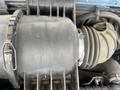 Close-up of a 2006 Ford Econoline engine component featuring a black air intake duct and a silver hose clamp