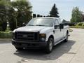 A white 2008 Ford F-250 Super Duty pickup truck with a black grill and front bumper parked in a driveway