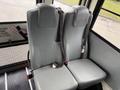 Two gray seats with seatbelts in a school bus setting