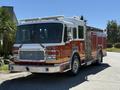 A 2004 American LaFrance Eagle fire truck with a red and white exterior featuring multiple compartments and equipment for firefighting