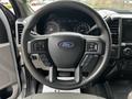 Steering wheel of a 2020 Ford F-350 with controls on both sides and the Ford logo in the center