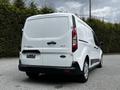 A white 2019 Ford Transit Connect van is parked with its rear doors closed showing the model and manufacturer logo