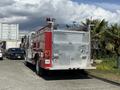 A red 1994 Volvo FE 42 fire truck with chrome details and emergency lights on the top is parked, showcasing its rear side and rear compartments for equipment storage