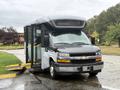 A gray 2020 Chevrolet Express van with a wheelchair ramp extended and doors open, designed for accessibility
