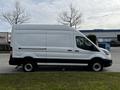 A 2020 Ford Transit van with a high roof and long body in white color positioned sideways on a grassy area