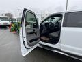 A white 2016 Ford F-150 with the driver's side door open showing the interior including a steering wheel and seat