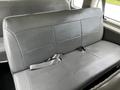 A gray leather bench seat from a 2004 Ford Econoline with seatbelts and a smooth texture