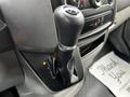 A gear shift lever of a 2016 Mercedes-Benz Sprinter with a textured black handle and a silver trim