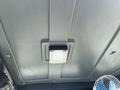 Interior view of a 2024 AGT Industrial Green QH13R Mini Excavator with overhead light and fan visible on the ceiling