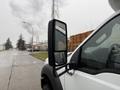 A 2011 Ford F-550 with a prominent side mirror displaying raindrops on the glass