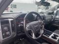 Interior view of a 2015 GMC Sierra 1500 showcasing the steering wheel dashboard and center console with controls and displays