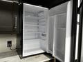 An open refrigerator with multiple shelves and a clean interior design in a 2021 Grand Design Recreational 311BHS