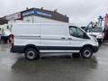 A white 2018 Ford Transit van is shown from the side with a sliding side door and black trim along the bottom of the vehicle