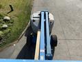 A 2012 Genie Z 45/25 aerial work platform with a blue boom arm and large wheels positioned on a paved surface