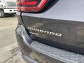 A close-up of the rear end of a 2015 Dodge Durango featuring the Durango badge and visible damage on the bumper