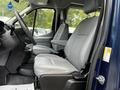 A 2017 Ford Transit 350 interior featuring two gray front seats and the steering wheel with control panels visible