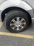 A 2010 Mercedes-Benz Sprinter with a flat tire and alloy wheel showing chrome spokes