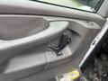 Close-up of the driver's side door panel of a 2014 GMC Savana featuring the door handle and window control switch