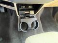 A cup holder in a 2014 Ford F-350 SD with a black plastic design situated in the center console compartment