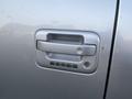 Close-up of a silver 2014 Ford F-150 door handle featuring a keypad with numbers for keyless entry