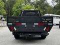 A black 2020 Ford F-350 SD viewed from the rear with a utility bed featuring a diamond plate design and multiple red and white lights