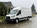 A white 2023 Ford Transit van with a black accent on the lower part and a large cargo area visible on the back