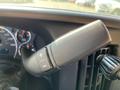 A close-up view of a control lever inside a 2014 Chevrolet Express featuring buttons for adjusting settings