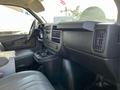 Interior view of a 2014 Chevrolet Express showing the dashboard and front seating area with a focus on the controls and console