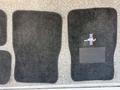 A set of black carpet floor mats for a 2003 Ford Mustang featuring the pony logo and red white and blue stripes