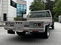 A 2008 Ford F-550 truck with a flatbed and a metal railing in the rear view