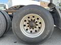 A close-up view of the rear wheel of a 2022 Freightliner Cascadia featuring a silver metallic rim and a rugged black tire with visible tread patterns and branding