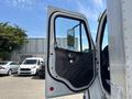 The door of a 2015 Freightliner M2 106 truck is open showcasing the interior door panel and mirror
