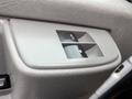 Interior door panel of a 2016 Chevrolet Express with window control buttons including an automatic window feature