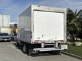 A 2023 Ford E-450 truck with a large white cargo box and a silver rear bumper parked in a lot