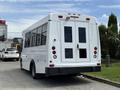 A white 2017 Chevrolet Express van with large windows and rear double doors