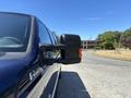A blue 2014 Ford F-250 SD with a side mirror in focus showing the angular styling and detailing of the vehicle