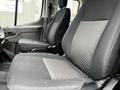 Two front seats of a 2023 Ford Transit featuring fabric upholstery with a geometric pattern and ergonomic design