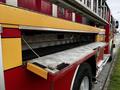 A red and yellow 2009 Spartan Gladiator fire truck with a lowered equipment storage compartment and visible ladder rack