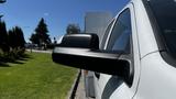 A close-up of a black side mirror on a white 2019 RAM 3500 truck