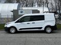 A white 2016 Ford Transit Connect van parked with a roof rack and side windows tinted