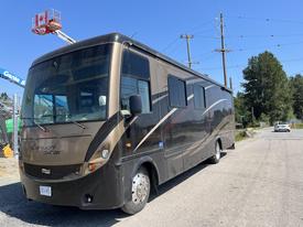 A 2008 Newmar Canyon Star 36 foot Class A motorhome with a sleek design and large windows parked on a gravel surface