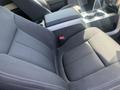 A black fabric seat in a 2014 Ford F-150 with visible stitching and armrest storage compartment