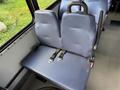 A two-seat bench with blue fabric upholstery and seat belts in a vehicle interior designed for safety and comfort