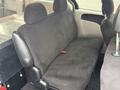 The interior of a 2011 Dodge Grand Caravan featuring a rear bench seat covered in dark fabric with headrests and seatbelt attachment