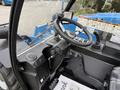 An interior view of a 2020 Genie GTH-5519 telehandler showcasing the steering wheel control panel and various operational buttons