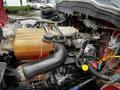 Detail of the engine compartment of a 2011 International 4400 showcasing various components including hoses and fluid reservoirs