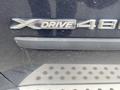 A close-up of the X Drive 48 badge on the side of a 2009 BMW X5