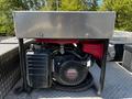 A Honda engine mounted on a metal platform used for powering equipment on a 2006 Emergency One Fire Truck