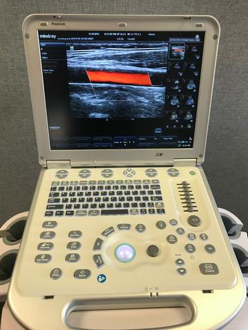 A Mindray M7 Ultrasound Machine with a large display screen showing a color image of anatomical structures and various control buttons and knobs below the screen