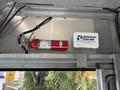 A red fire extinguisher mounted on a metal surface next to a white first aid kit labeled "American First Aid"